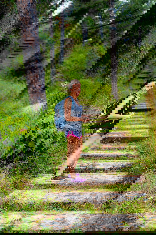Woman wearing a backpack and shorts hiking up stone steps in Guatape Colombia