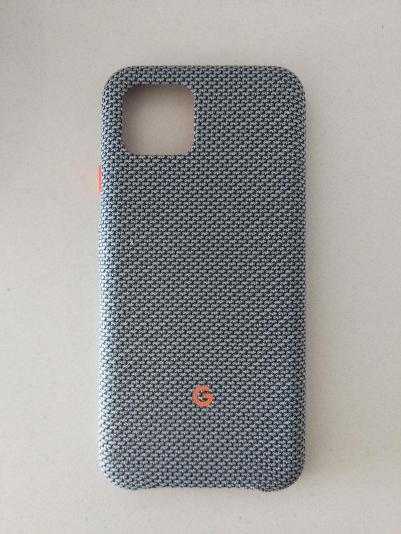 The back of a grey phone case with an orange button.