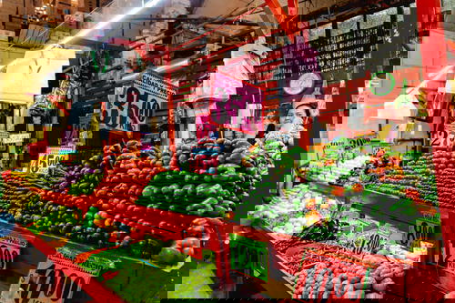 Rows of tomatoes, chayote and bell peppers at a city market in Mexico