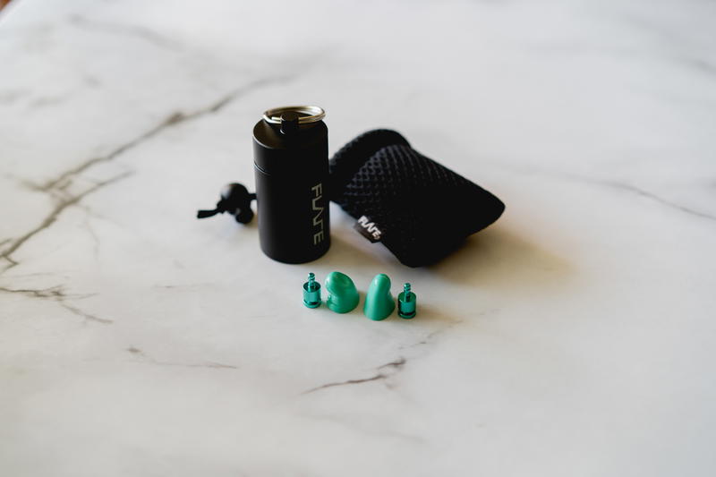 A black and green vaporizer sitting on a marble table.