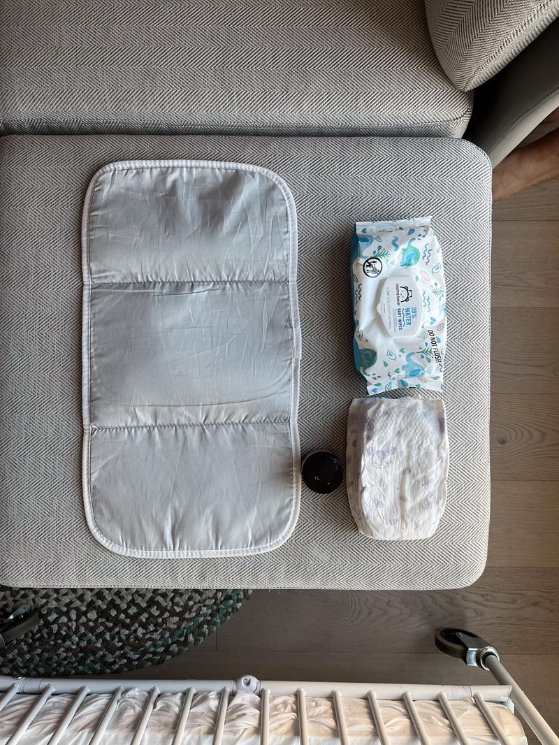 A temporary baby changing station, with a changing pad, diapers and wipes.