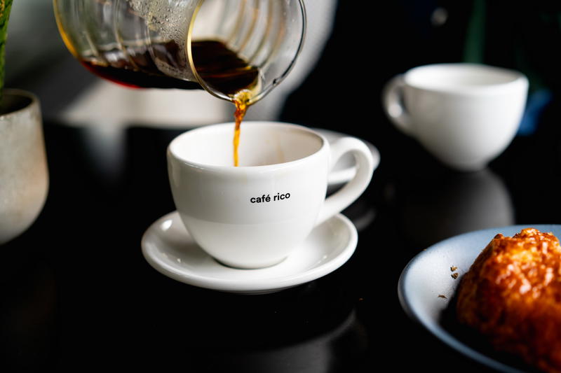 Coffee being poured into a cup on a table.