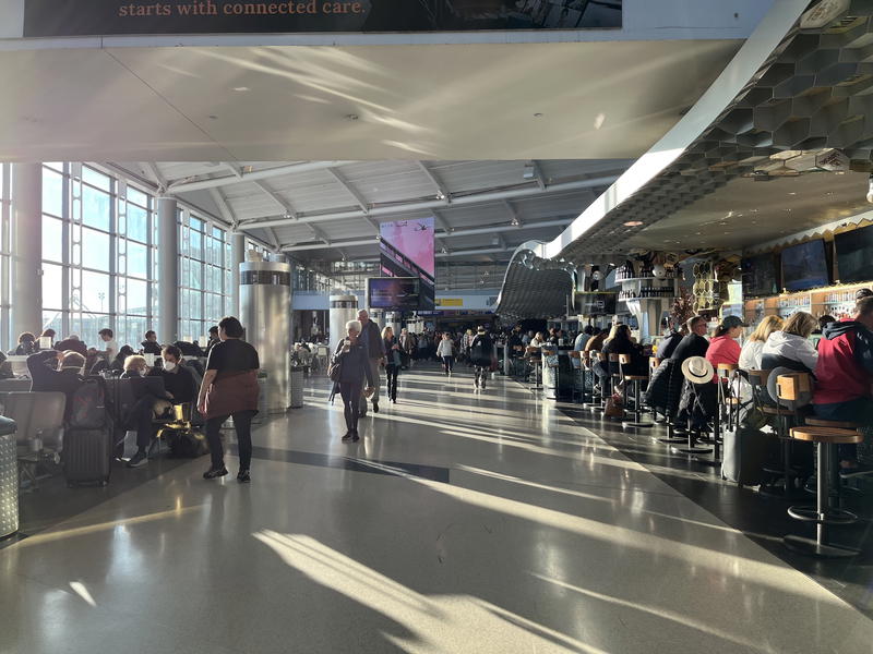 A group of people walking through an airport.