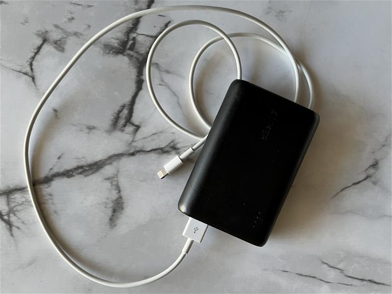 A black power bank connected to a charger.