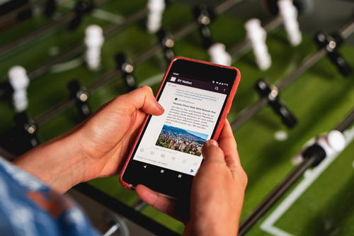 Woman using a smartphone next to a foosball table