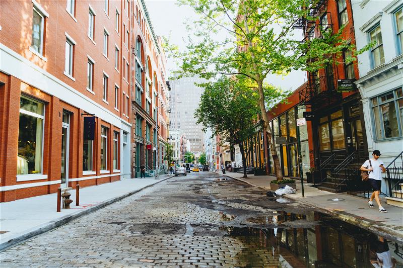 Cobblelstone historic NYC street with water puddles after a summer rain