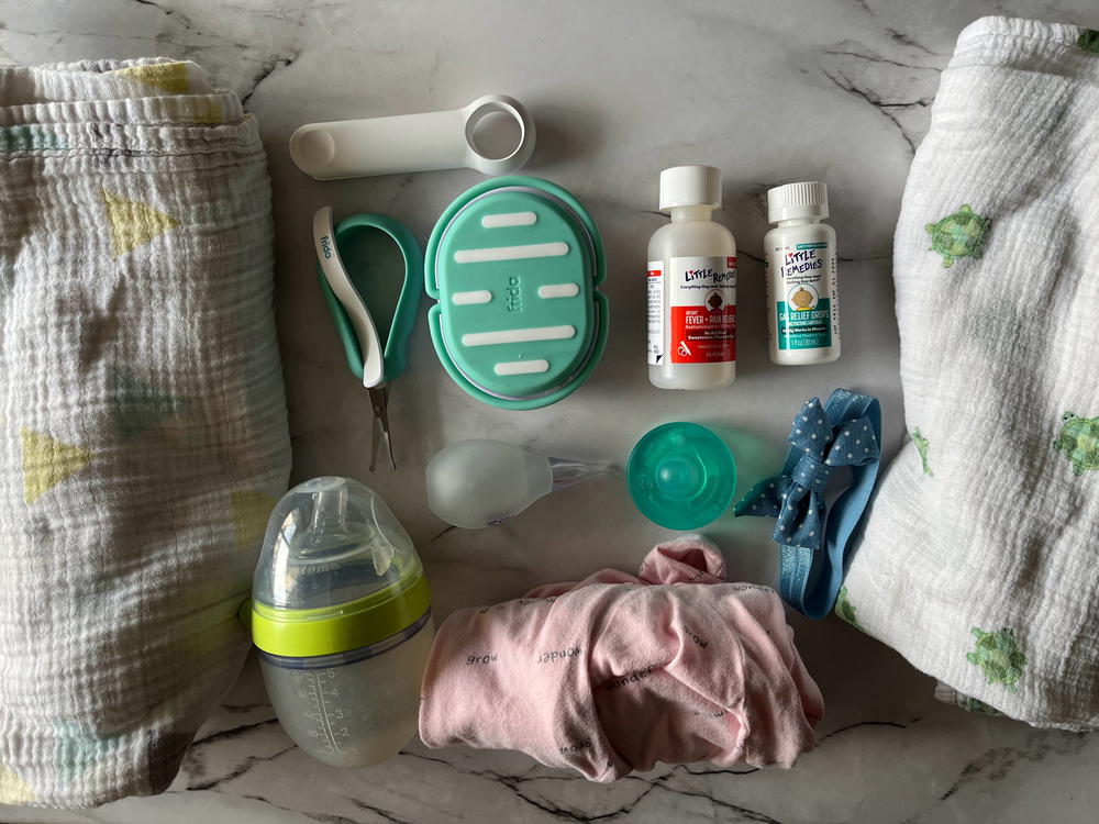 A list of baby items laid out on a marble table.