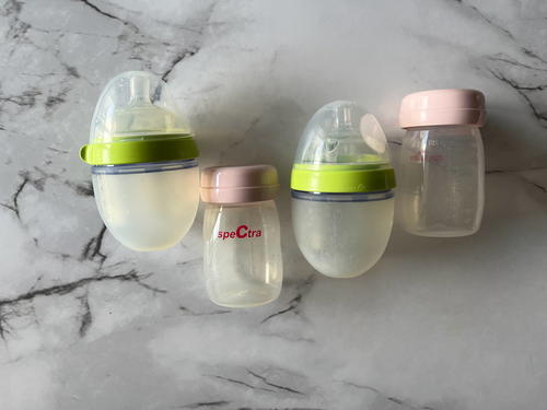 Three baby bottles on a marble surface.