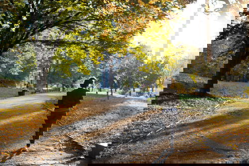 Figure of a girl walking along a paved path in Fort Greene Park in Brooklyn, New York