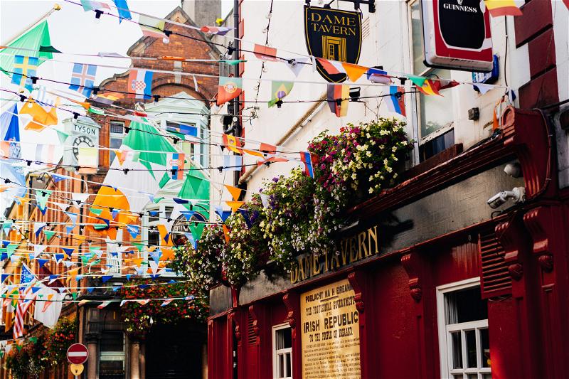 Flags and streamers lining a red tavern on a street in Dublin