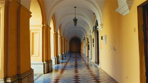 Historic yellow and white archways with tiled floor design