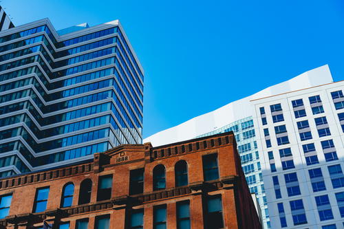 New skyscrapers and old industrial red brick building against a blue sky in Boston