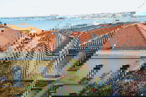 View of Lisbon rooftops and busy streets from a penthouse hotel room