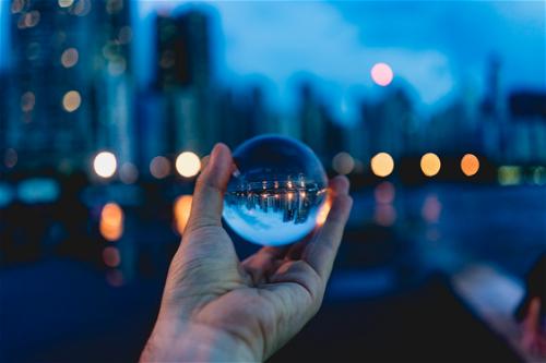 Reflection of skyscrapers and city lights in a glass sphere