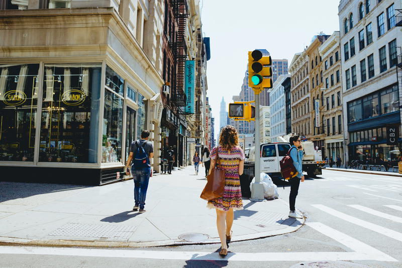 Woman walking on Broadway in Soho and Grand St in Soho, New York City