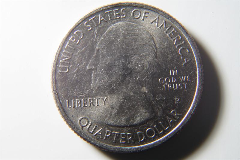 A quarter on a white surface.