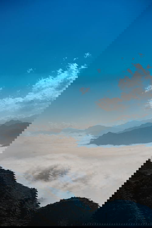 Mountain peaks rise above clouds during hike in Asia