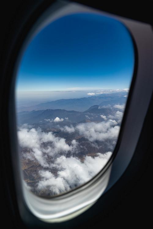 Airplane window view of jagged rugged mountain range