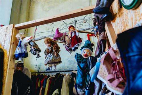 Eastern European dolls hanging with vintage clown dolls in a flea market
