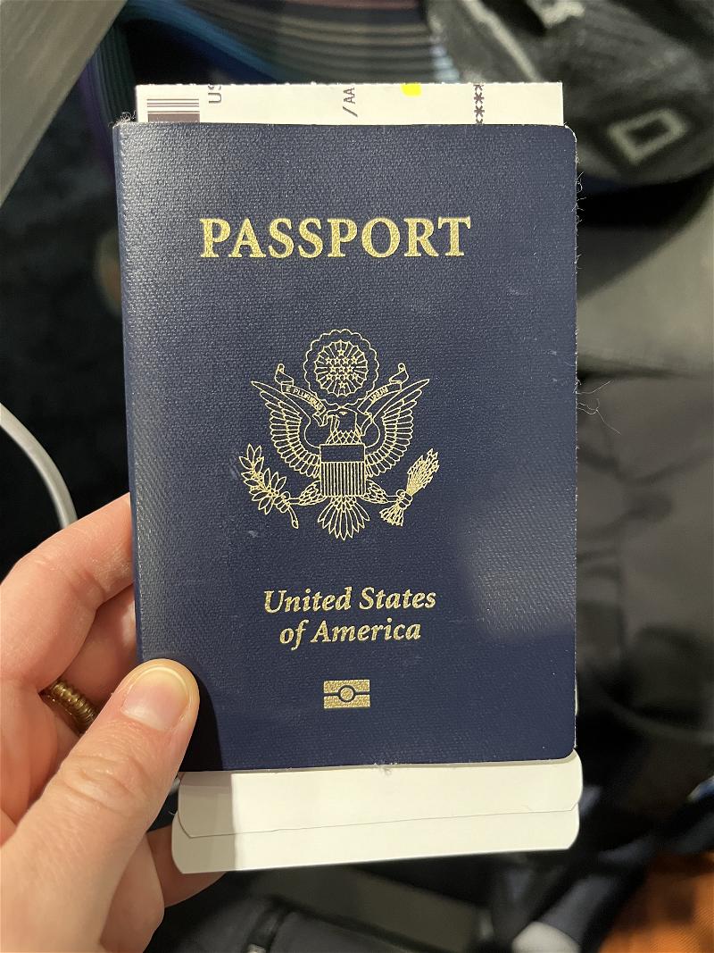 A person holding a passport in their hand.