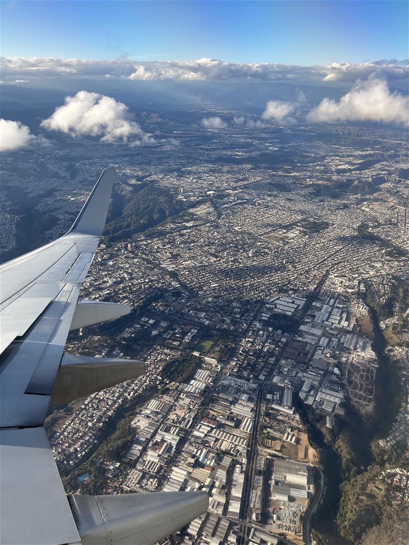 A view of a city from the wing of an airplane.
