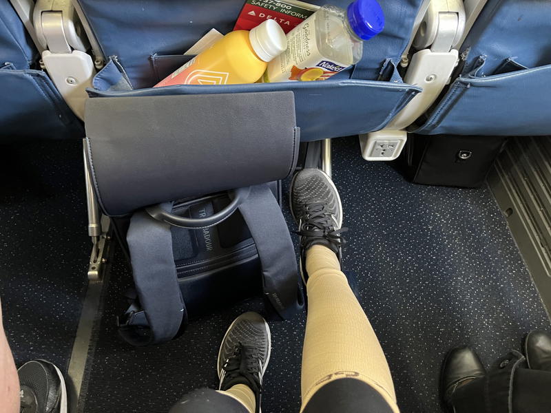 A picture of a person's feet on an airplane seat.