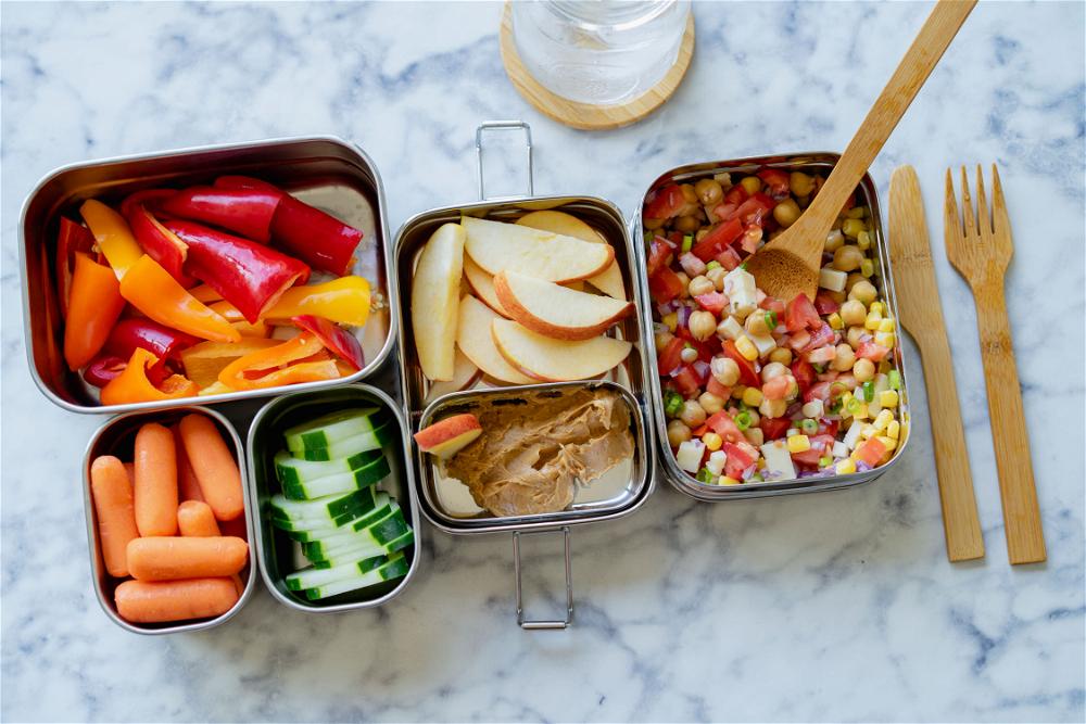 A lunch box filled with vegetables and a fork.