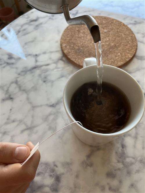 A person pouring coffee into a cup.