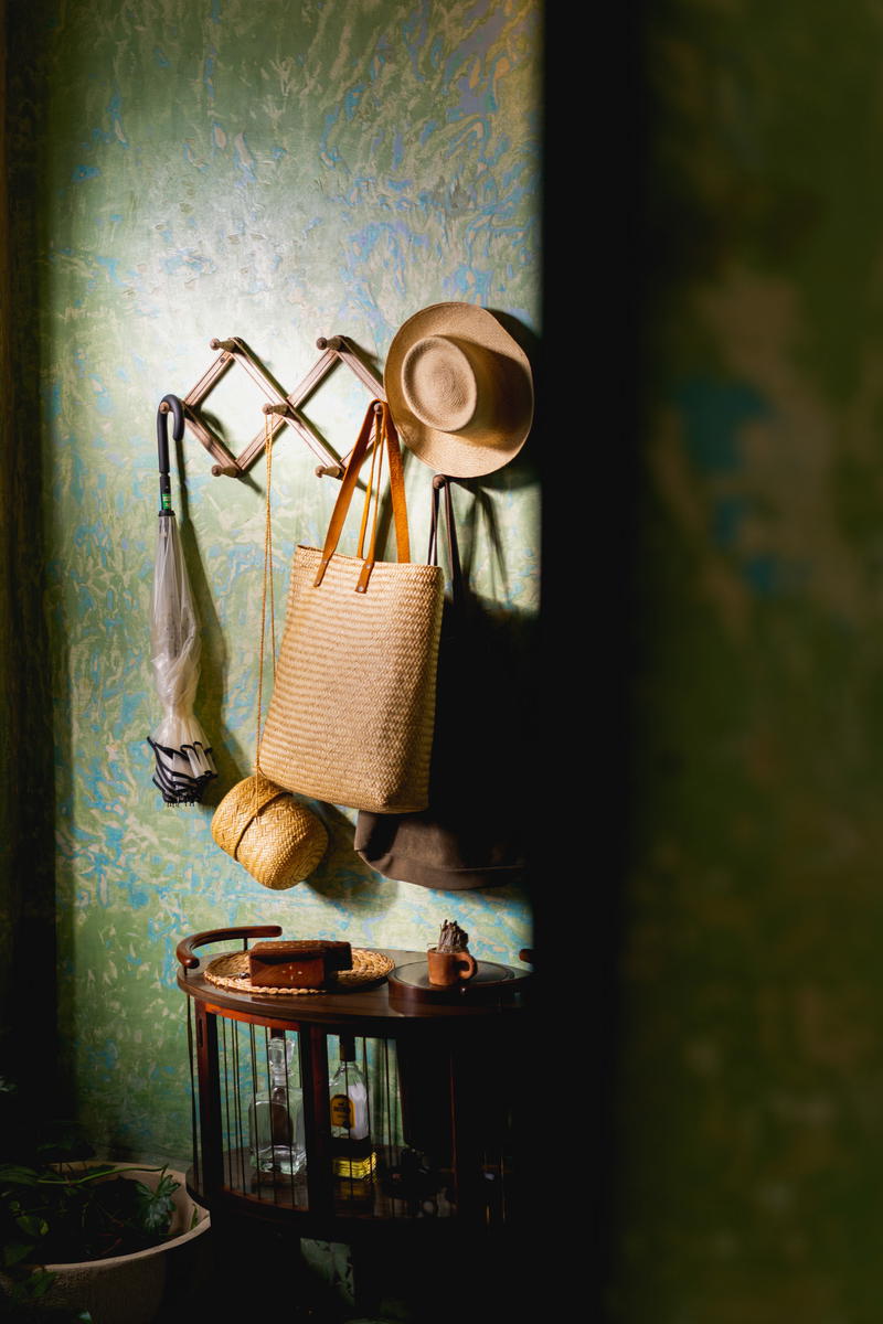 A hat hanging on a hook in a room.