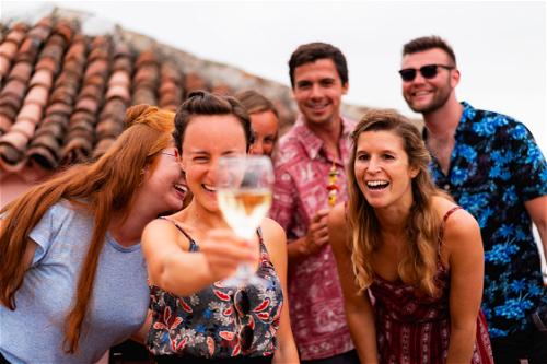 A group of friends holding up a glass of wine.