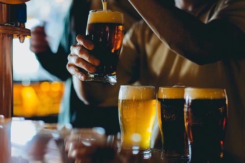 A man pouring a beer into a glass.