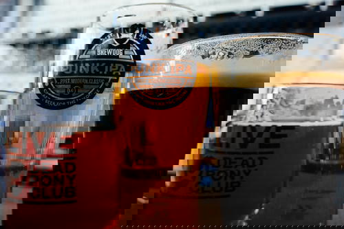 Two glasses of beer on a table.