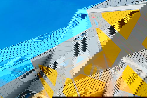 A yellow and white building with a blue sky behind it.
