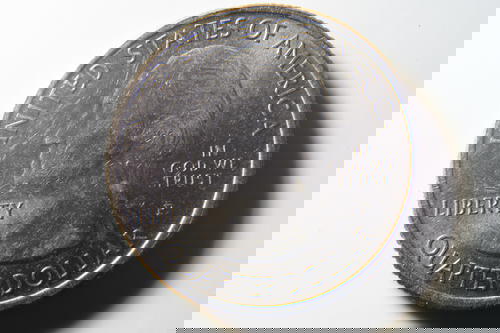 A quarter on a white surface.
