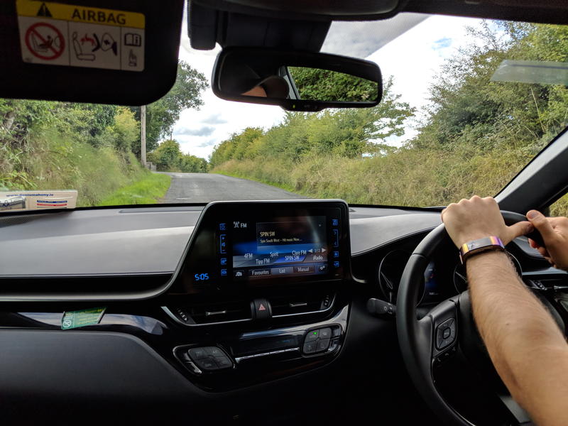 A man driving a car in the countryside.