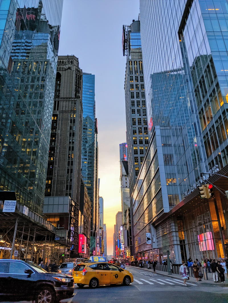 A city street with tall buildings and taxis.