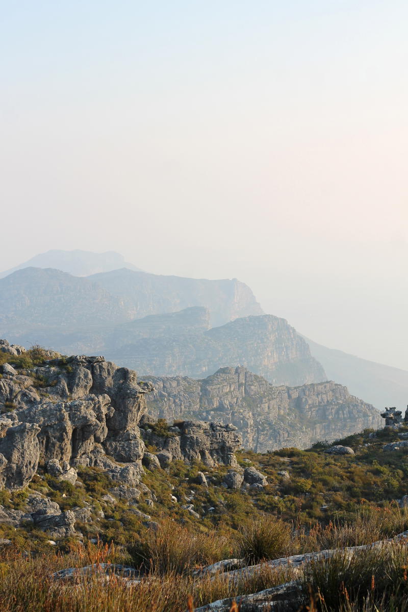 A person is standing on top of a rocky mountain.