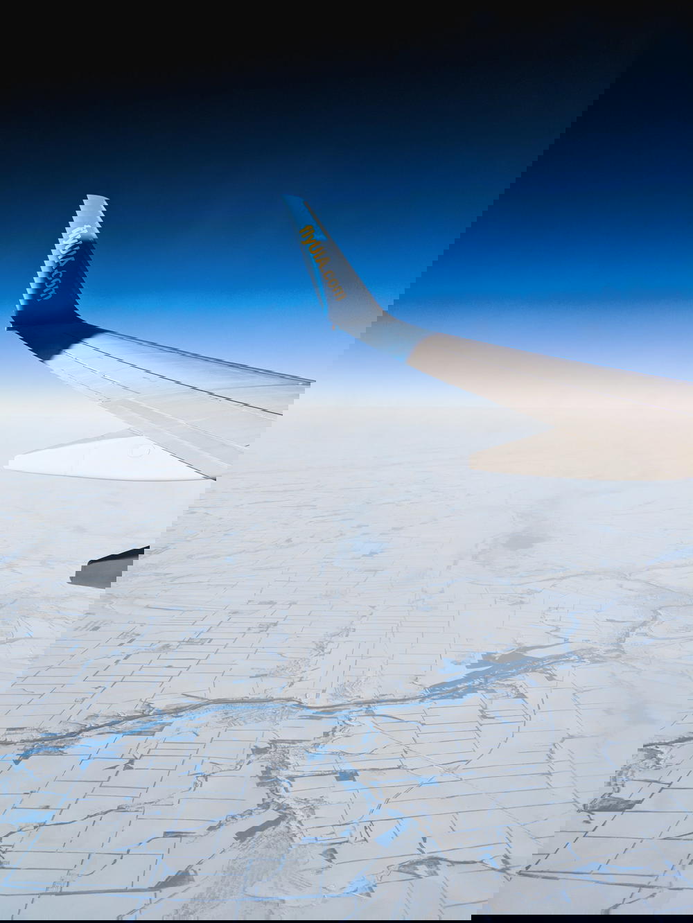 Airplane flying over a frozen landscape