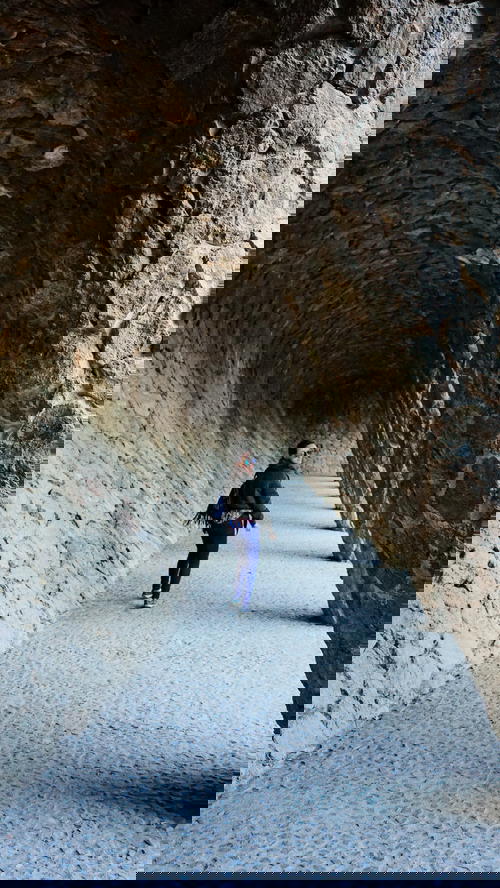 Woman walking in tunnel of Gaudi arches in Depositphotos Park Guell Barcelona Spain