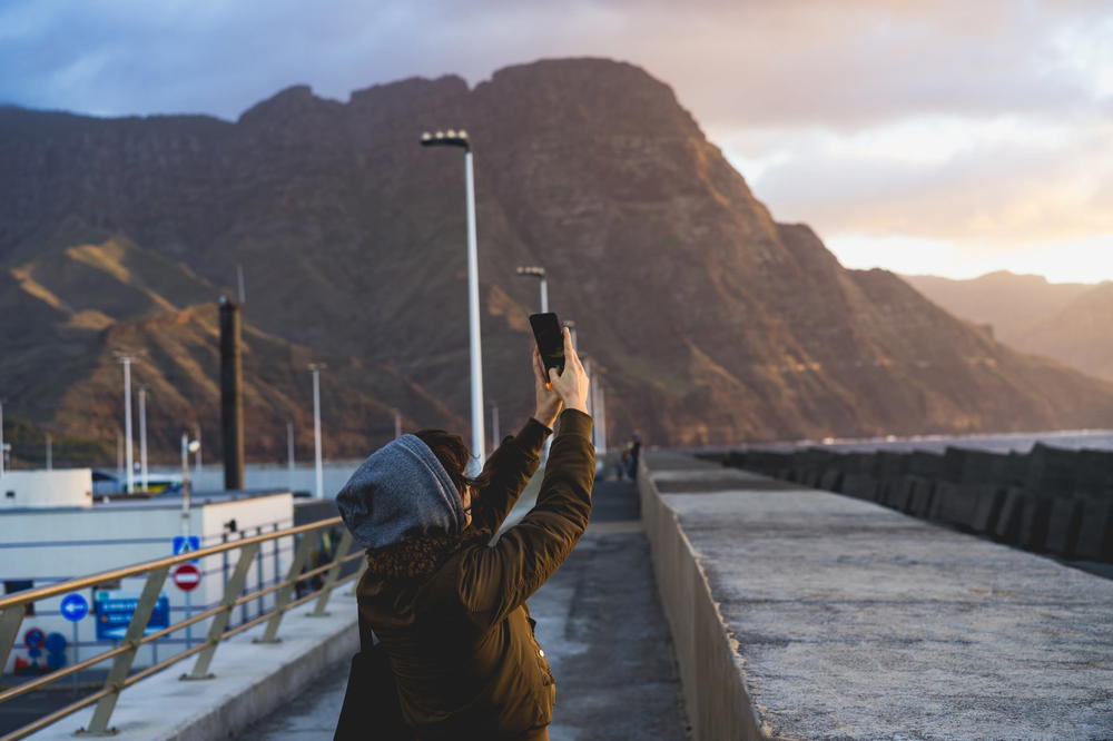 Becca taking a photo of the sunset in Puerto de las Nieves