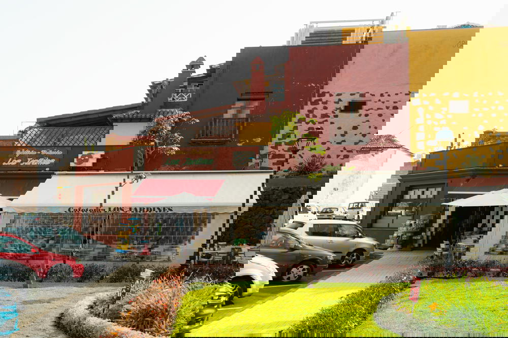 White tented restaurant addition with some cars parked nearby