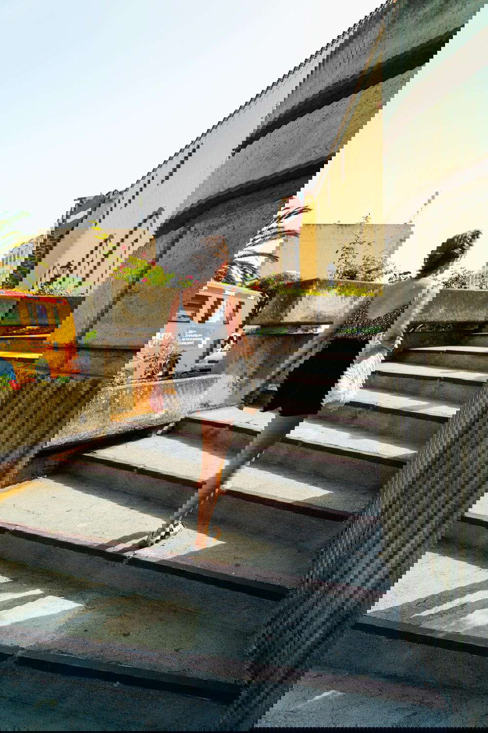 Woman walking up sunny stone steps