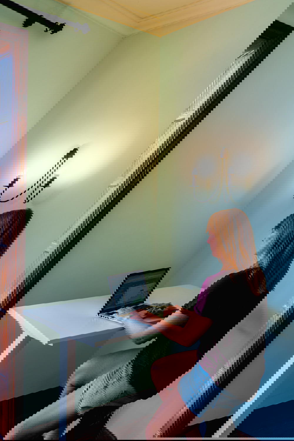 A woman sitting at a desk using a laptop at Nine Coliving in Tenerife, Spain.