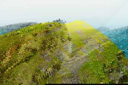 An aerial view of a mountain in Sri Lanka with green grass on top.