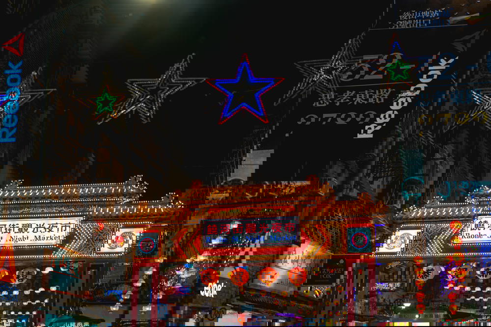 A bustling city street in Taipei at night.