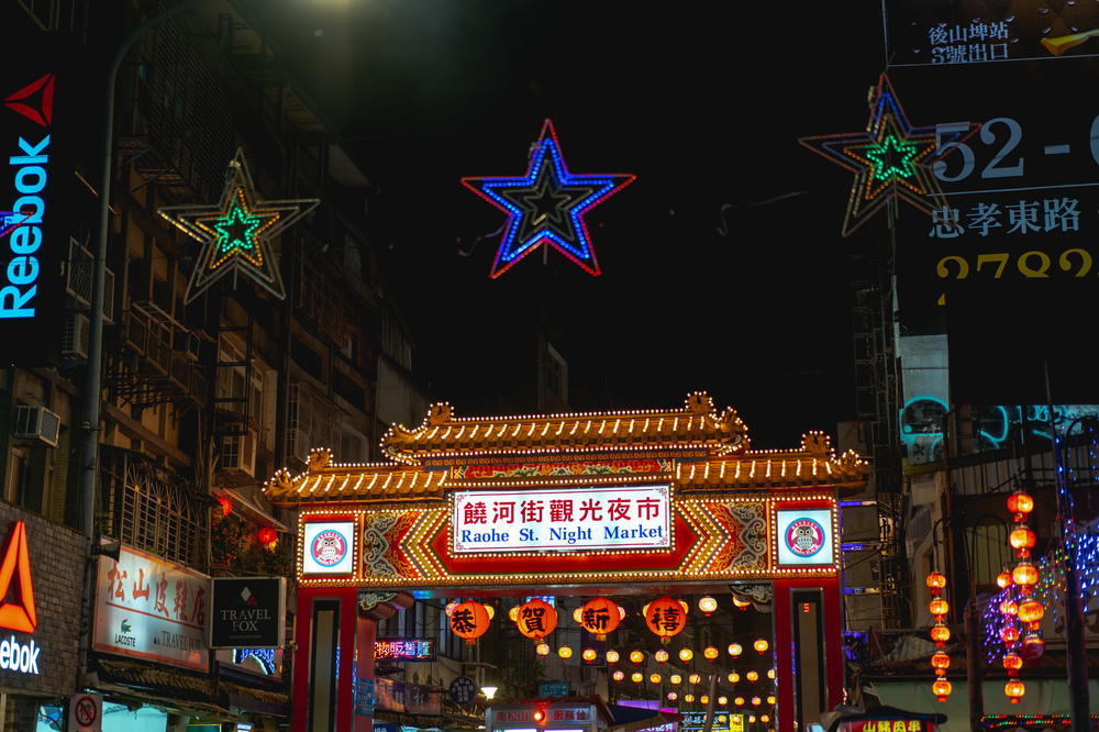 A bustling city street in Taipei at night.