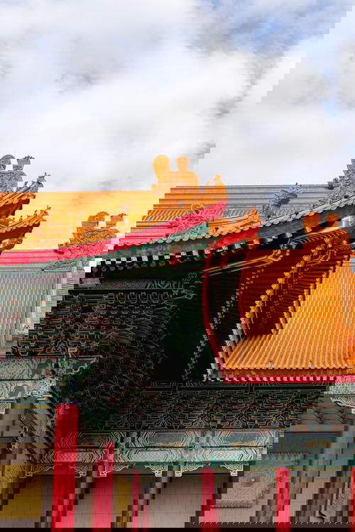 Architectural detail of orange tile roofing, green painted design and red columns at the Taiwan National Concert Hall