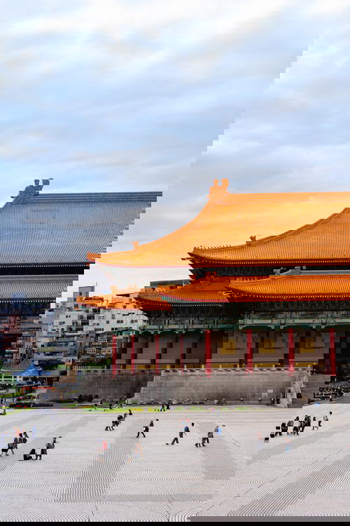 National Concert Hall of Taiwan's orange tiled roof and red column architecture with people walking in a plaza