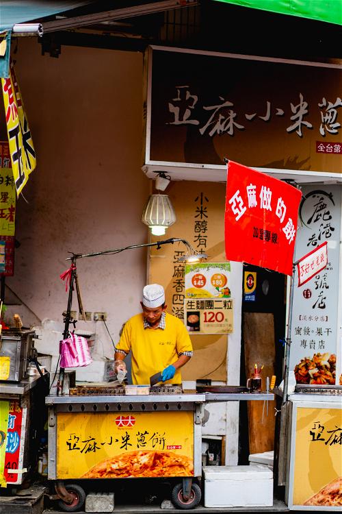 Street vendor cooking street food at a cart in Danshui Taipei
