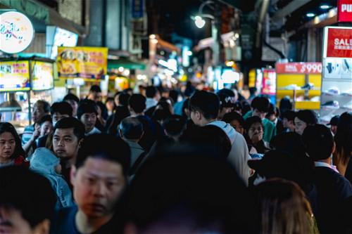 Visiting ShiLin night market among crowds of people, neon signs and street food vendors